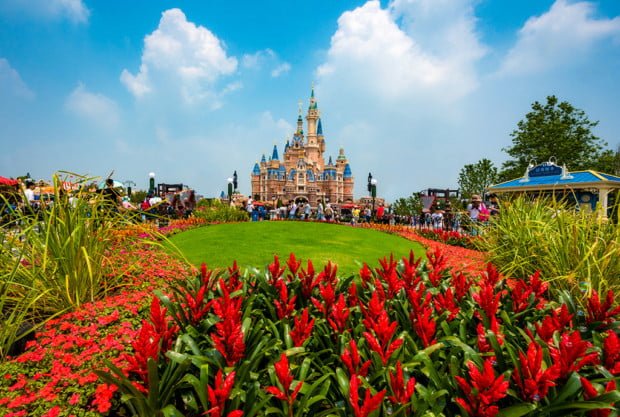 enchanted-storybook-castle-daytime-wide-bricker-puffy-clouds-flowers-shanghai-disneyland